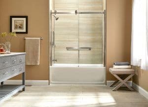 a remodeled shower and tub with tan walls and sliding doors
